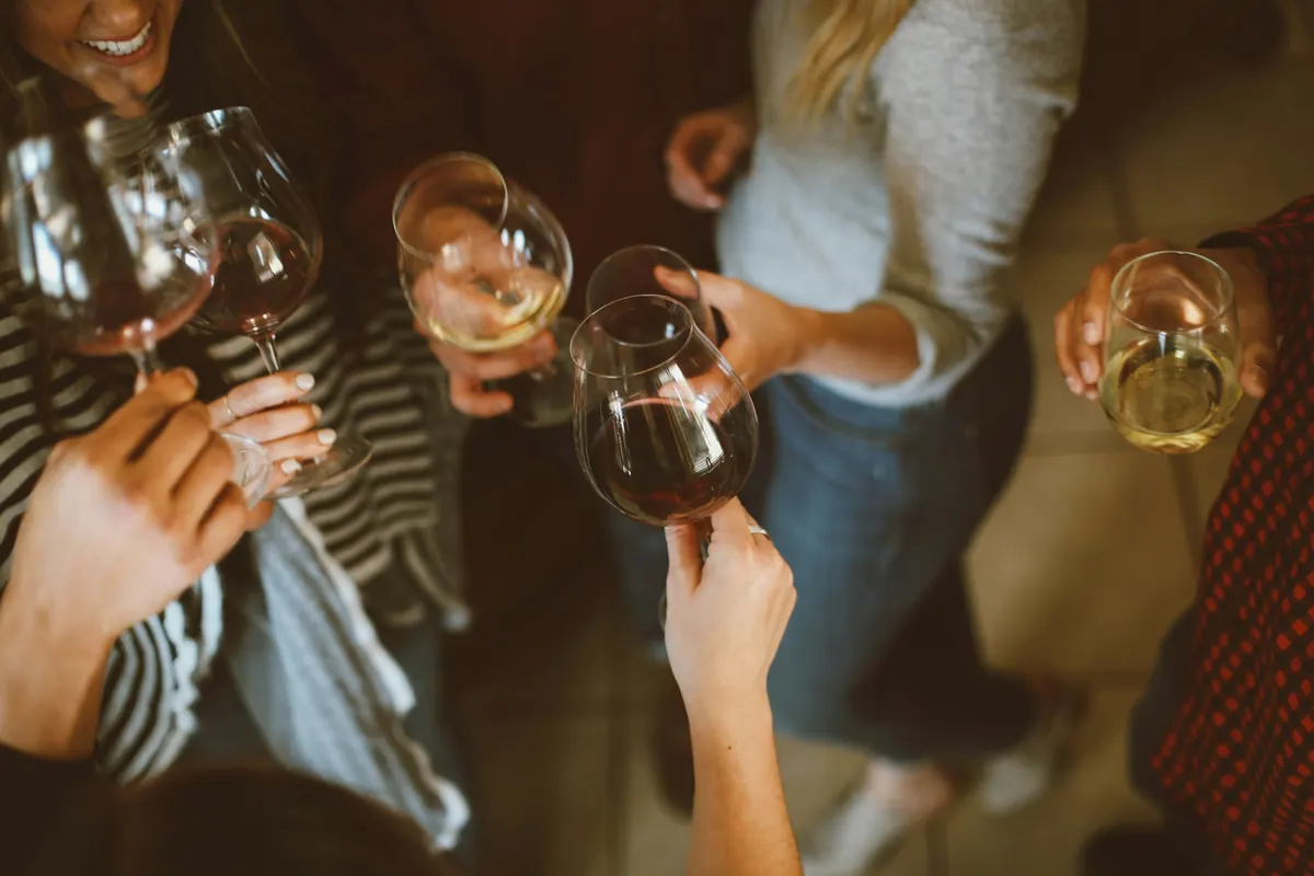 Friends raising their glasses around a shared table.